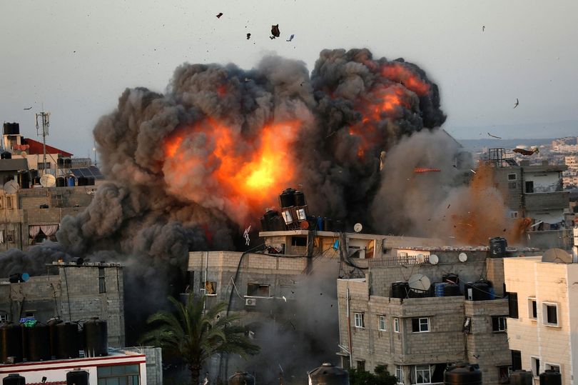 A ball of fire erupts from a building in Gaza City's Rimal residential district on May 16