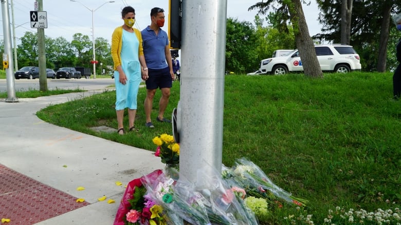 A couple pays respects at a makeshift memorial in London, Ont., on Monday, where four family members were killed Sunday in a hit and run that police believe was planned. (Colin Butler/CBC)