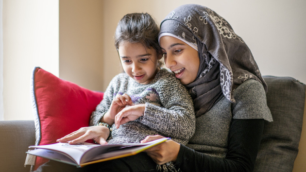 Big sister reads stories to her little sister